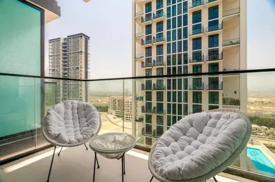 two chairs and a table on top of a building at DAYF-LAV Brand New Apartment with Balcony in JVC in Dubai