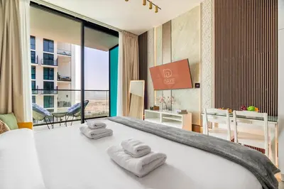 a bedroom with a large bed with two towels at DAYF-LAV Brand New Apartment with Balcony in JVC in Dubai