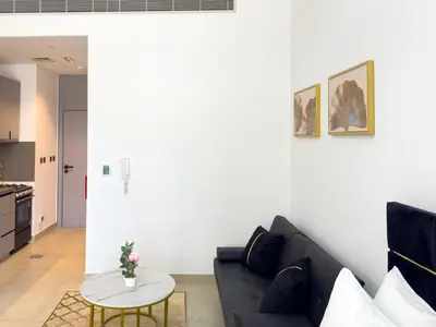 a living room with a black couch and a table at Stylish Studio Fast Wi-Fi 5 Min to Business Bay in Dubai