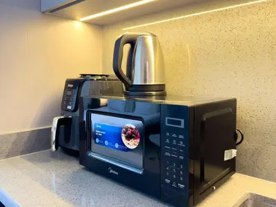 a microwave with a coffee pot on top of it at Stylish Studio Fast Wi-Fi 5 Min to Business Bay in Dubai