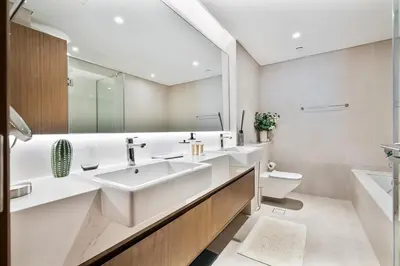 a white bathroom with a sink and a toilet at Stylish 1 BR in Canal Front with Pool and Gym Access in Dubai