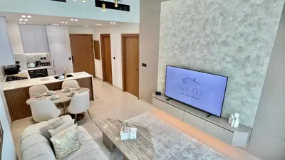 a living room with a couch and a tv on a wall at Luxury Apartment in Binghatti Amber in Dubai