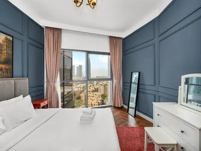 a bedroom with a white bed and a large window at Burj Khalifa View 2 Bedroom Apartment in Dubai