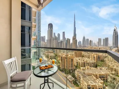 a balcony with a table and chairs and a view of the city at Burj Khalifa View 2 Bedroom Apartment in Dubai