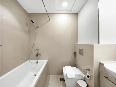 a bathroom with a tub and a toilet and a sink at Burj Khalifa View 2 Bedroom Apartment in Dubai