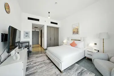 a white bedroom with a bed and a couch at Luxury Retreat in Arjan with Refined Living in Dubai