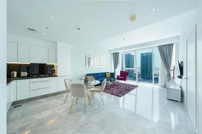 a kitchen and living room with a table and chairs at Designer 1BR Retreat With Stunning Canal View in Dubai