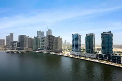 a view of a city with a river and buildings at Designer 1BR Retreat With Stunning Canal View in Dubai