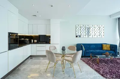 a living room with a table and a blue couch at Designer 1BR Retreat With Stunning Canal View in Dubai