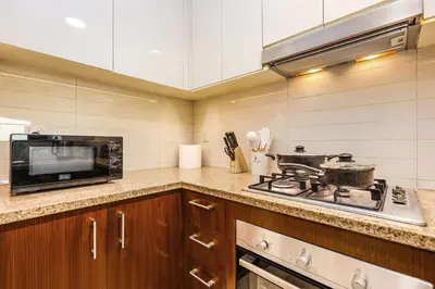 a kitchen with a stove and a microwave at FIRST CLASS 2BR Sky Views City Vibes in Dubai