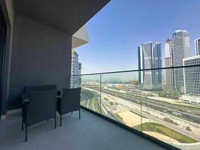 a balcony with two chairs and a view of a city at AWS Holiday Homes - Relaxing Stylish Studio in Dubai