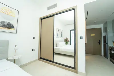 a bedroom with a sliding glass door leading to a bed at AWS Holiday Homes - Relaxing Stylish Studio in Dubai