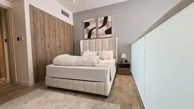 a bedroom with a white bed in a room at Stylish 1BR Loft TH in Rukan in Dubai