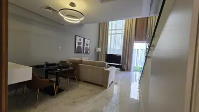 a living room with a couch and a table with chairs at Stylish 1BR Loft TH in Rukan in Dubai