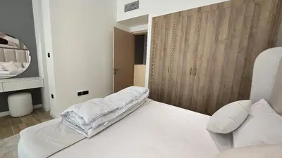 a bedroom with a white bed and a wooden wall at Stylish 1BR Loft TH in Rukan in Dubai