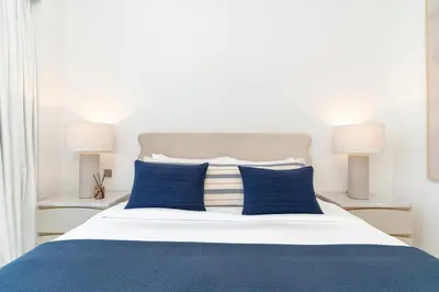 a bed with blue and white pillows and two lamps at Grande, Luxurious 2 BR, Burj Khalifa & Fountain view in Dubai