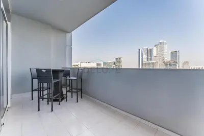 a dining room with a table and chairs on a balcony at High-Rise 2BR with Dubai Water Canal View, Quick Access to Downtown, Vera Tower, Business Bay by Deluxe Holiday Homes in Dubai