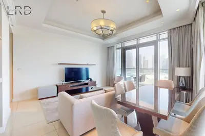a living room with a table and chairs and a television at Iconic Burj View in Downtown Dubai in Dubai