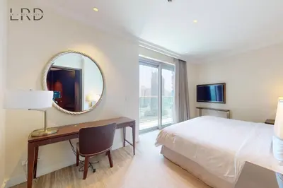 a bedroom with a bed and a desk and a mirror at Iconic Burj View in Downtown Dubai in Dubai