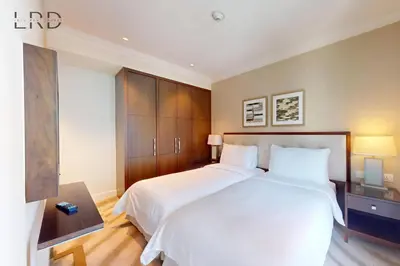 a bedroom with a large white bed and wooden cabinets at Iconic Burj View in Downtown Dubai in Dubai