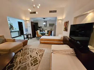 a large living room with a couch and a tv at Stunning 1Bedroom Apartment 5 min walking distance Metro and JBR Beach in Dubai