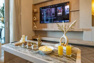 a living room with a table with food and a tv at Exclusive Burj Khalifa View, Steps From Dubai Mall, Infinity Pool in Dubai