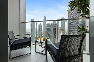a balcony with two chairs and a table with a view at Exclusive Burj Khalifa View, Steps From Dubai Mall, Infinity Pool in Dubai