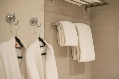 a bathroom with white towels hanging on a wall at Exclusive Burj Khalifa View, Steps From Dubai Mall, Infinity Pool in Dubai