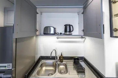 a small kitchen with a sink and a microwave at Stylish 1BR in Marina - 5 Min Walk to Beach in Dubai