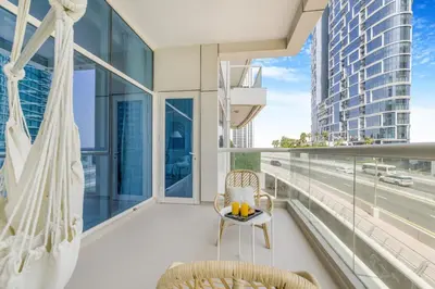 a balcony with a hammock and a view of a city at Stylish 1BR in Marina - 5 Min Walk to Beach in Dubai