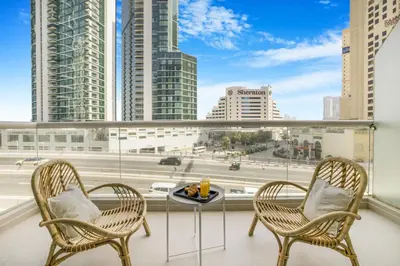 two chairs and a table on a balcony with a view of a city at Stylish 1BR in Marina - 5 Min Walk to Beach in Dubai