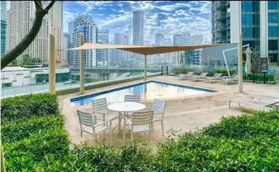a patio with a table and chairs next to a pool at Vogue Marina 52-42 Towers near Ain Dubai and JBR Beach, Two Bedroom Apartment with Balcony Canal and Skyline views, Access to all Amenities in Dubai