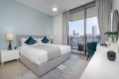 a white bedroom with a bed and a balcony at Vogue Marina 52-42 Towers near Ain Dubai and JBR Beach, Two Bedroom Apartment with Balcony Canal and Skyline views, Access to all Amenities in Dubai