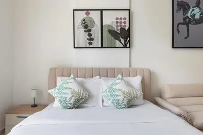 a bedroom with a white bed with four pillows at Luxurious JVC Studio Near Circle Mall & Parks in Dubai