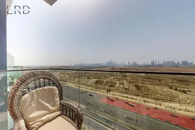 a chair on a balcony with a view of the city at Chic and Aesthetic Studio! Move-In Ready in Dubai