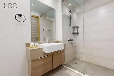 a bathroom with a sink and a glass shower at Chic and Aesthetic Studio! Move-In Ready in Dubai