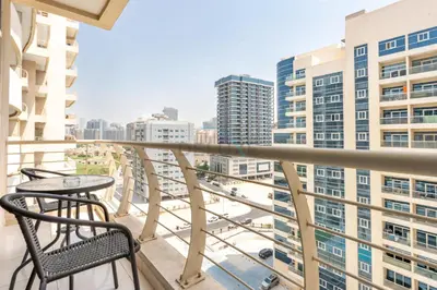 a balcony with a table and chairs and buildings at Studio with Balcony Facing the Community, Located Near Golf Clubs and Cricket Stadium, Royale Residence 1 , Dubai Sports City by Deluxe Holiday Homes in Dubai