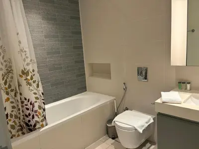 a bathroom with a tub and a toilet and a sink at Best Emaar Beachfront view one bedroom in Dubai