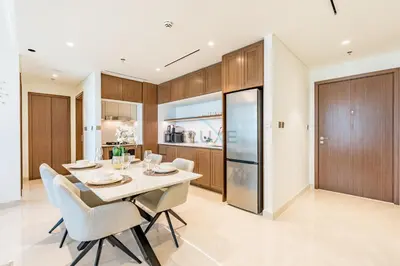 a kitchen and dining room with a white table and chairs at 1BR With Private Beach Access, Near Dubai Marina Walk, Next to Dubai Harbour Marina & Yacht Club, Palace Beach Residence, Dubai Marina by Deluxe Holiday Homes in Dubai