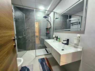 a bathroom with a shower and a sink and a mirror at The Dorra Bay Offers Stunning 2bedroom Duplex JBR Sea View Marina Canal view in Dubai