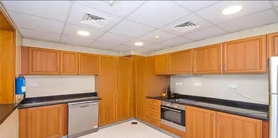 a kitchen with wooden cabinets and a white ceiling at The Dorra Bay Offers Stunning 2bedroom Duplex JBR Sea View Marina Canal view in Dubai