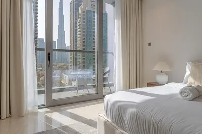 a bedroom with a bed and a large window at Luxury Burj & Fountain View Retreat in Dubai