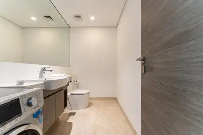 a bathroom with a toilet and a sink and a door at Luxury Burj & Fountain View Retreat in Dubai
