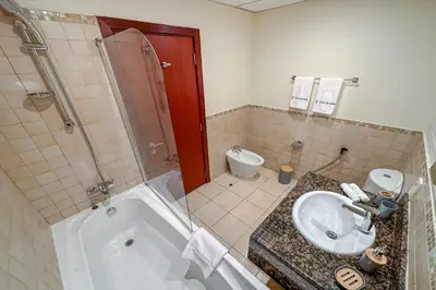 a bathroom with a sink and a tub and a toilet at Centrally Located Close to Beach in Dubai