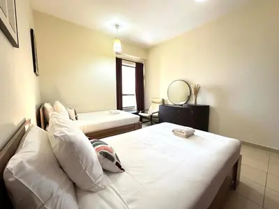 a hotel room with two beds and a mirror at Centrally Located Close to Beach in Dubai