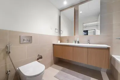 a bathroom with a toilet and a sink and a mirror at Stylish 2BR at Creek Grove Near Downtown in Dubai