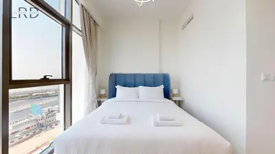 a bedroom with a large white bed and a window at Cozy and Modern 1BR for 2 in Dubai