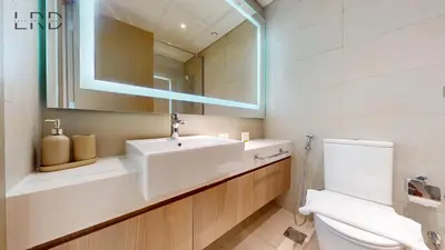 a bathroom with a sink and a toilet and a mirror at Cozy and Modern 1BR for 2 in Dubai