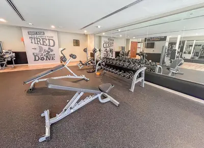 a gym with several tread machines and a mirror at Stylish 1BR - Burj Khalifa View in Dubai