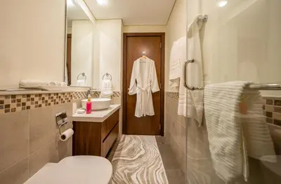 a bathroom with a toilet and a sink and a mirror at Stylish 1BR - Burj Khalifa View in Dubai